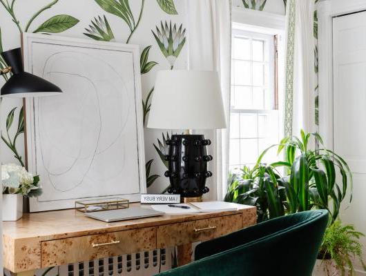 office with small desk green chair and botanical wallpaper